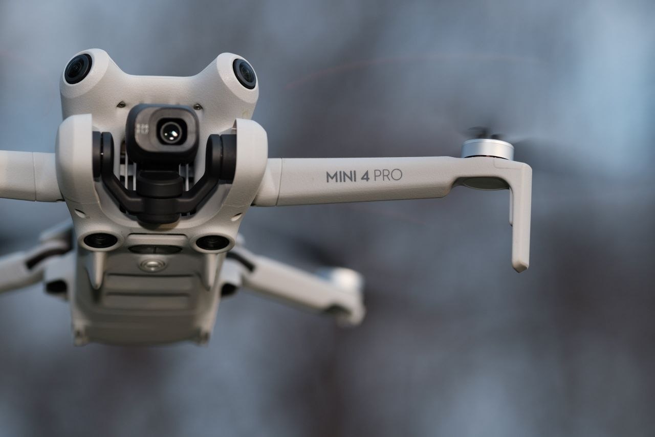 DJI Mini Pro 4 drone on sandy beach with ocean in background